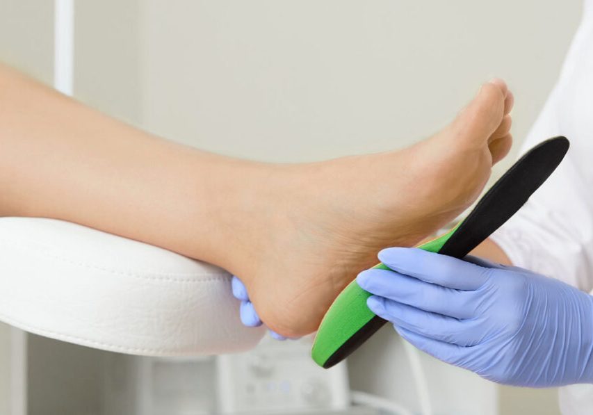 A clean foot with a professional applying a correction device