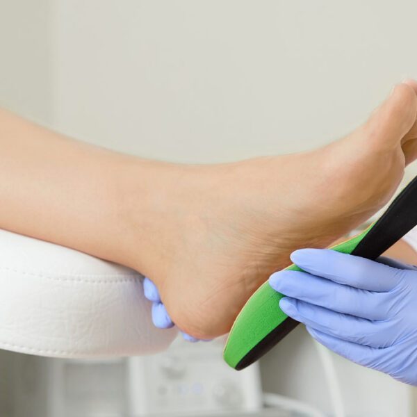 A clean foot with a professional applying a correction device