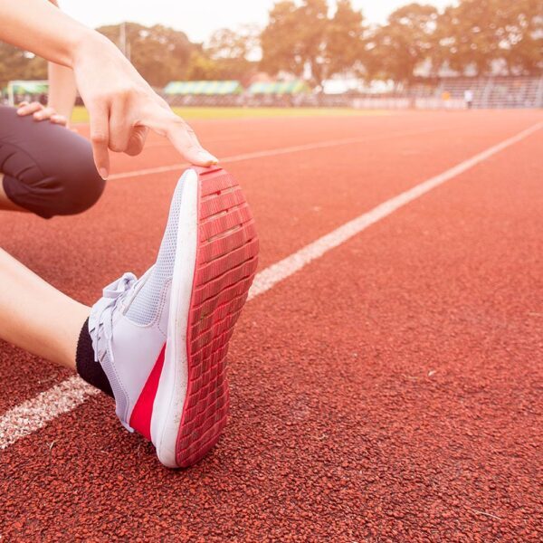 Sporty woman is stretch in sport field